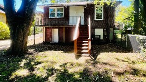 A two-story brick house with a visible front door and windows. - Stylish 3BR Home Sleeps 8 w/ Grill – Near CrossPlex & Downtown (Birmingham)