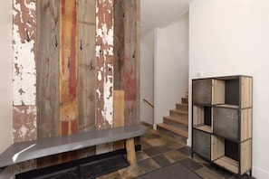 A staircase with a wooden wall and a metal bench in the foreground.