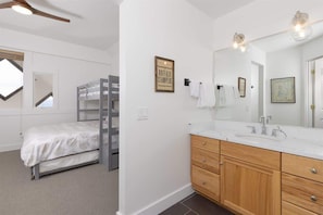 A bedroom with a bunk bed, a large mirror, wooden cabinets, and a ceiling fan. - Ski-In/Ski-Out 3 Bedroom Moonlight Basin (Big Sky)