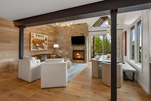 Una sala moderna con chimenea, televisor montado y una zona de estar acogedora.