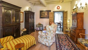 A traditional living room with a sofa, armchair, and a large wooden cabinet.