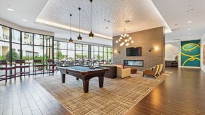 A spacious indoor area with a pool table, seating, and a large window offering a view of greenery. - Getaway | Hidden Gem | Free-Parking (Woodbridge)