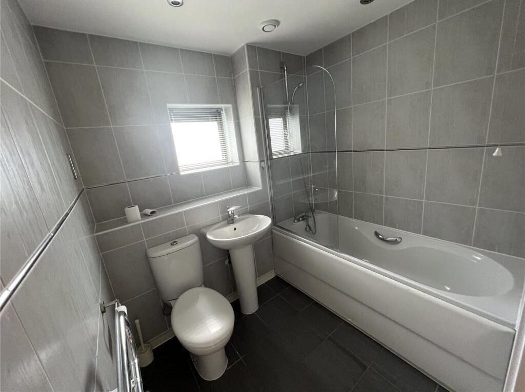 A bathroom with a toilet, sink, and bathtub.