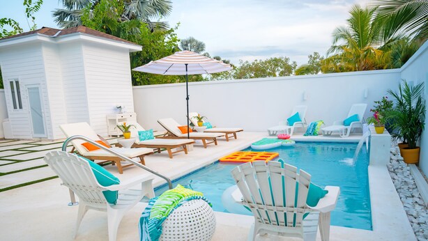 A poolside area with lounge chairs, a small building, and a pool. - Entire Condominium Home away from Home with Pool, Near Beach (Nassau)
