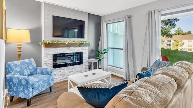 A living room with a fireplace, a sofa, a coffee table, and a TV.