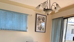Ein gemütliches Wohnzimmer mit Korbmöbeln, einem Couchtisch mit Getränken und einem gerahmten Bild an der Wand.