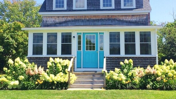 A two-story house with a blue front door, large windows, and a chimney. - Updated Biddeford Pool Beach House (Biddeford)