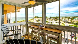A balcony with a view of the ocean and a town.