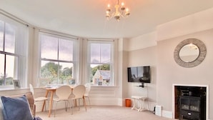 A spacious living room with large windows, a fireplace, a television, and a cozy seating area. - St Catherine's Lookout,  Niton, Isle of Wight (Niton)