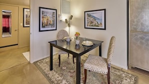 A dining area with a table, chairs, and a rug. There are framed pictures on the wall and a lamp on the table. - The Guest Dahl House of Sedona (Sedona)