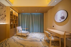 A cozy room with a sofa, a small table, a desk, and a bookshelf. - zhaona • Guofeng Intelligent Hotel (Dongguan)