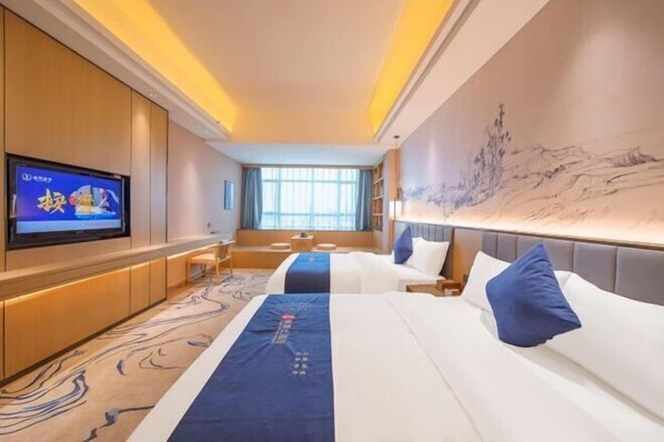 Une chambre d’hôtel dotée d’un grand lit, d’un téléviseur à écran plat fixé au mur, d’une grande fenêtre et d’une fresque murale.