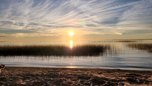 A beach with a sunset over water and clouds. - Upper Red Lake all season destination!  (Waskish)