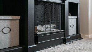 Un mueble de entretenimiento negro con un televisor de pantalla plana montado encima.