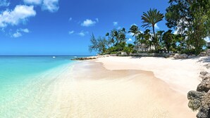A beach with clear turquoise water, white sand, and palm trees. - The Great House | Beach Front - Located in  Exquisite St. Peter with Private Pool (Mullins)