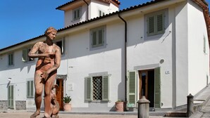A statue in a courtyard with a building in the background.