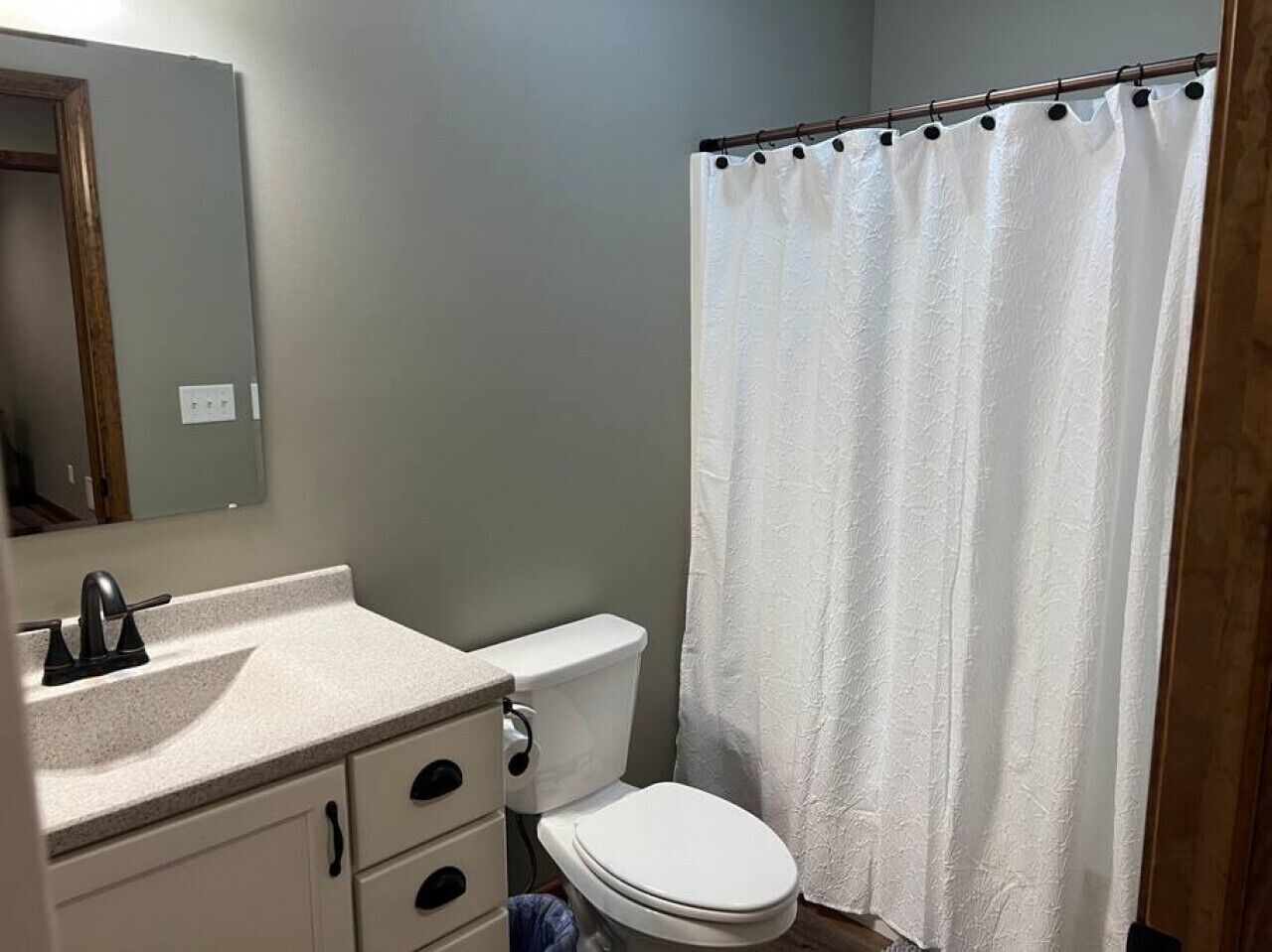 A bathroom with a toilet, sink, and shower curtain.