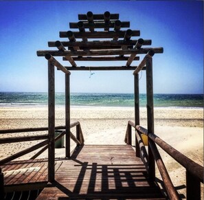 Une structure en bois située sur la plage, offrant une vue sur l’océan.