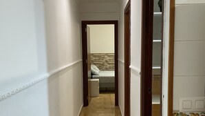 A narrow hallway with wooden flooring and white walls. - Casa Oceano - 2 Bedroom Apartment (San Fernando)