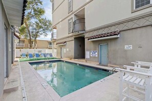 A swimming pool with a lifeguard chair, a sign indicating no lifeguard on duty, and a door labeled "Shower Room."