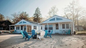 A beach house with a patio area featuring outdoor seating.