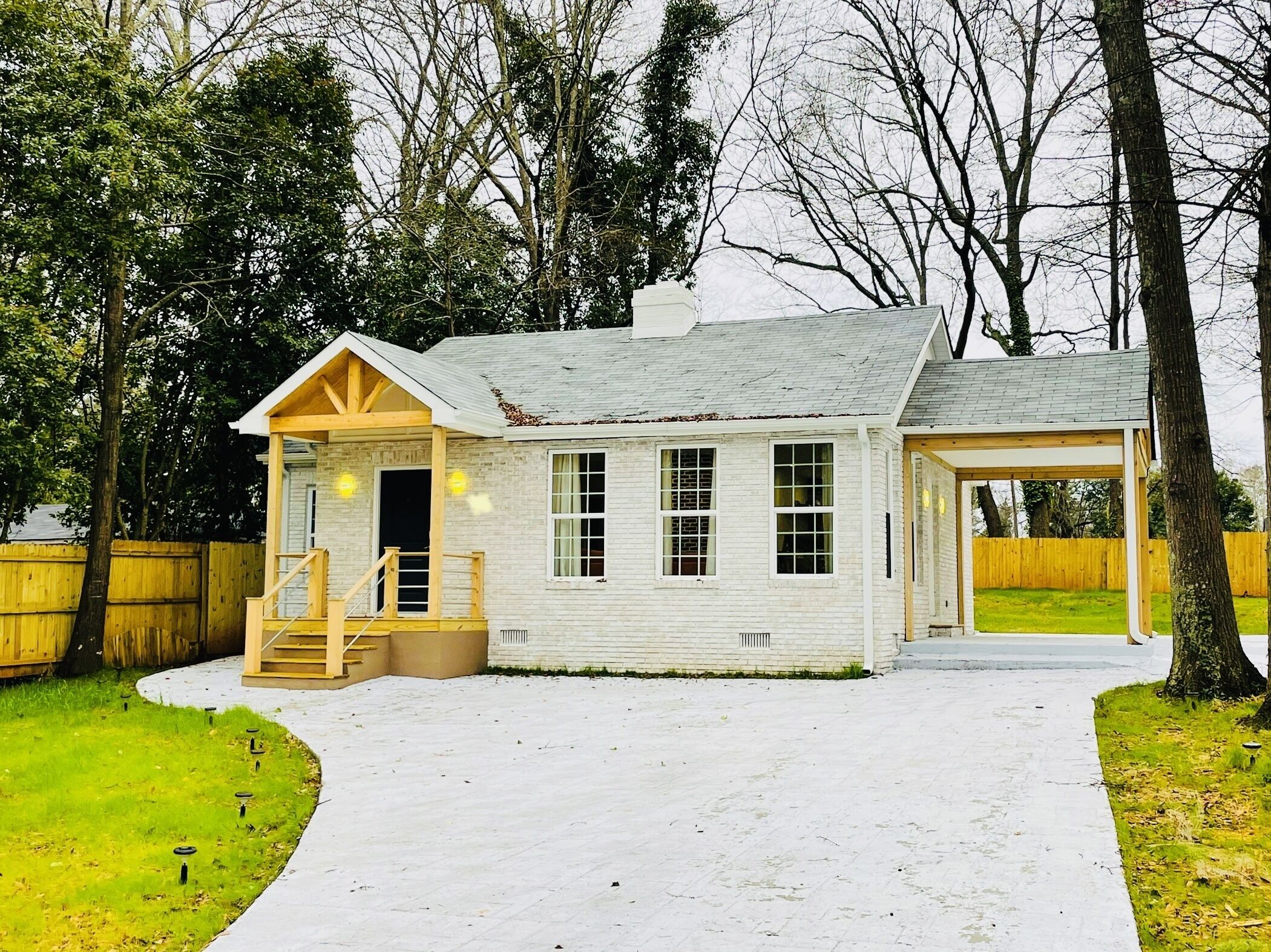 A small, single-story house with a covered porch and a garage.