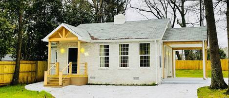 A small, single-story house with a covered porch and a garage.