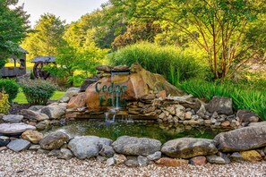 Stroll through the tranquil garden, featuring a serene waterfall and lush greenery surrounding Cedar Falls.
