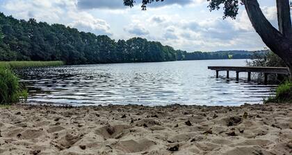 Vacation apartment in a cozy farmhouse by the bathing lake with large garden and sauna