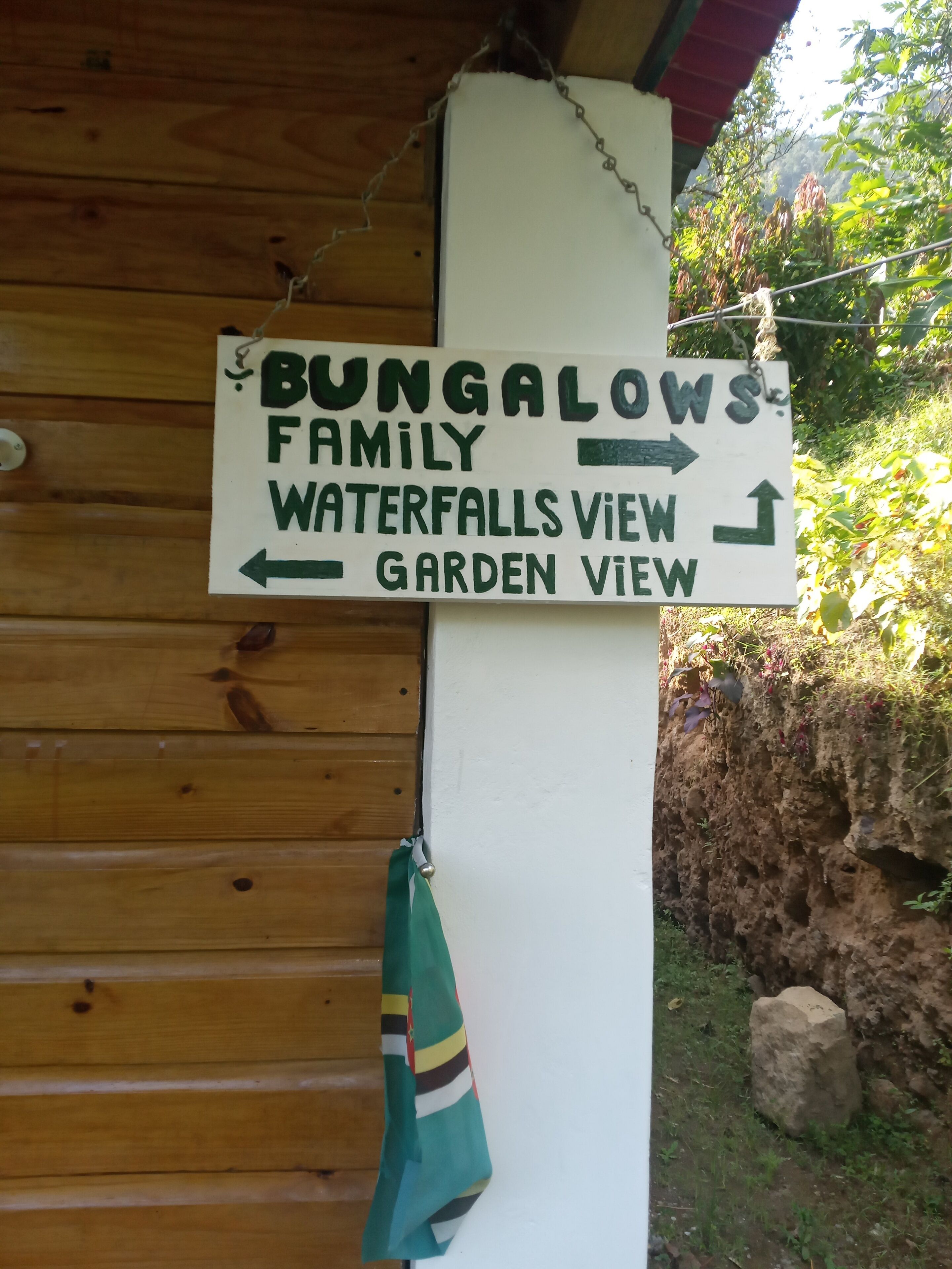 Placa indicando BUNGALOWS FAMILY com destino a VISTA DAS CASCATAS e VISTA PARA O JARDIM.
