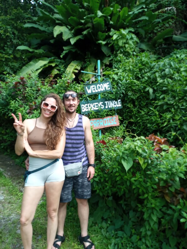 Two people standing in front of a sign that reads "Welcome to Berkeley's Jungle Paradise."