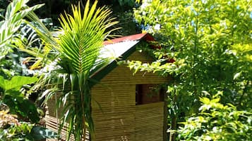 Una pequeña casa de bambú con un letrero que indica un baño.