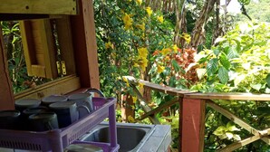 A kitchen area with a sink, a purple dish rack, and a tiled countertop. - Berkey's Jungle Paradise (Roseau)