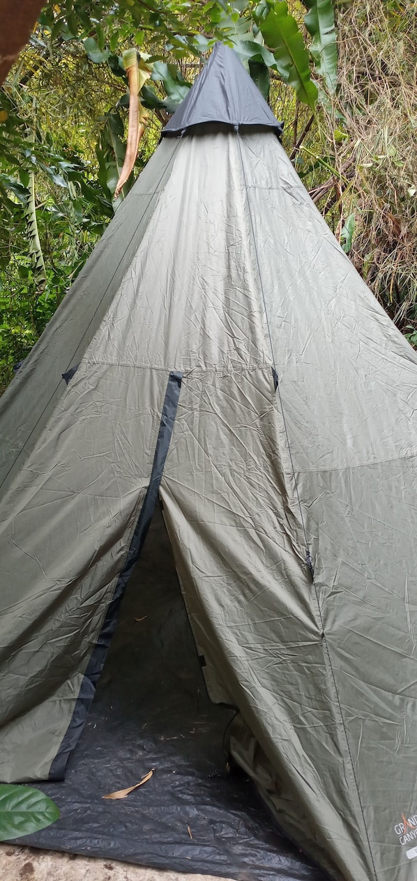 A tent with a peaked roof, a central entrance, and a ground entrance. - Berkey's Jungle Paradise (Roseau)