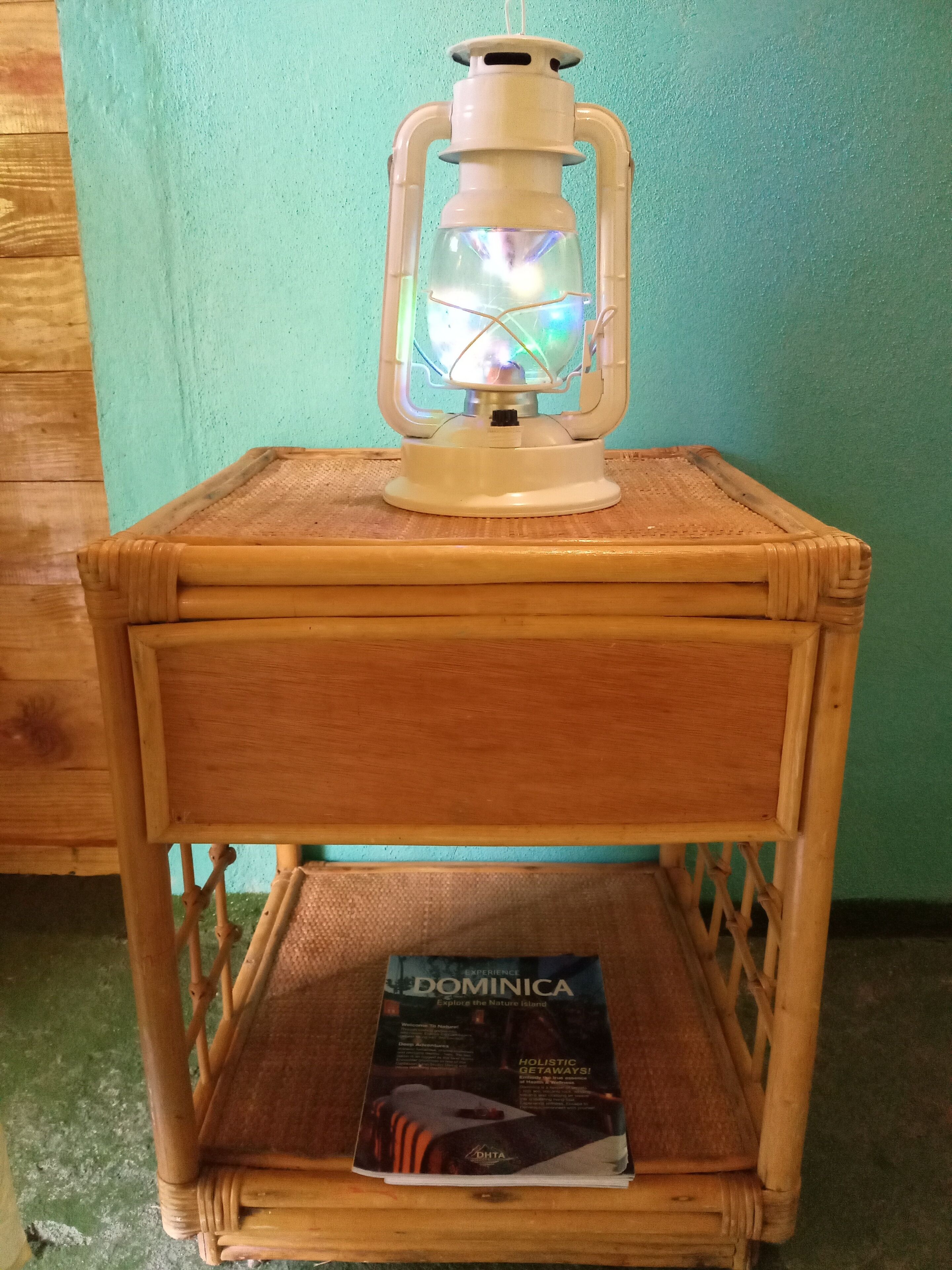 Un comodino in legno con una lanterna e una brochure intitolata "Dominica".