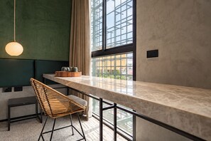 A modern bar area with a marble countertop, a hanging light fixture, and a view of the outside through large windows. -  Goose Living Bangkok BTS Phra Khanong (Bangkok)
