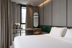 A modern hotel room with a large bed, a desk with a mirror, and a view of the city. -  Goose Living Bangkok BTS Phra Khanong (Bangkok)