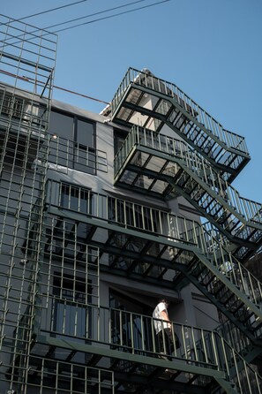 A multi-story building with external fire escapes and a visible elevator shaft. -  Goose Living Bangkok BTS Phra Khanong (Bangkok)