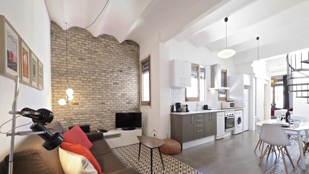 Eine moderne Wohnung mit Wohnbereich, Küche und Essbereich.