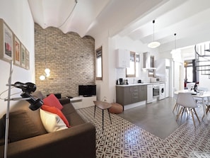 A modern apartment with a living area, kitchen, and dining space.