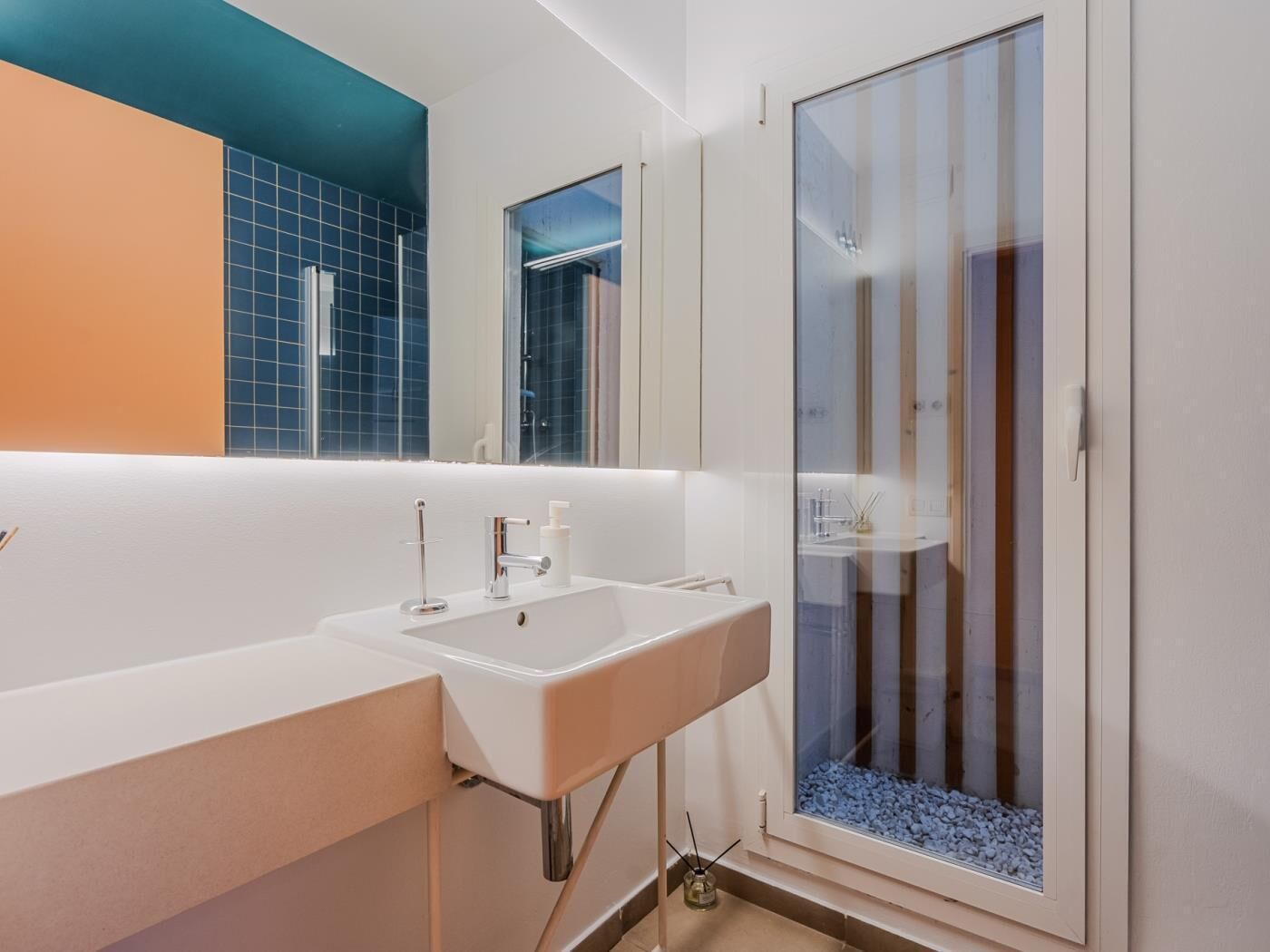 A modern bathroom with two sinks, a glass shower enclosure, and a large mirror.