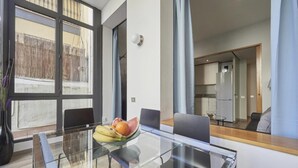 Ein moderner Essbereich mit einem Glastisch, Stühlen und einer Obstschale.