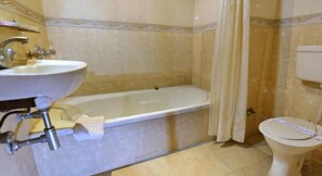 A bathroom with a bathtub, toilet, and sink.