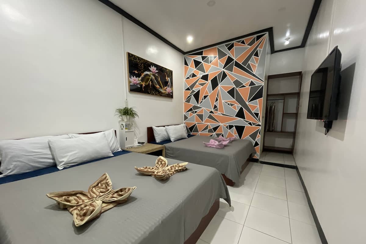 Une chambre d’hôtel moderne avec deux lits, un panneau décoratif au mur, un téléviseur à écran plat et une petite table agrémentée d’une plante.