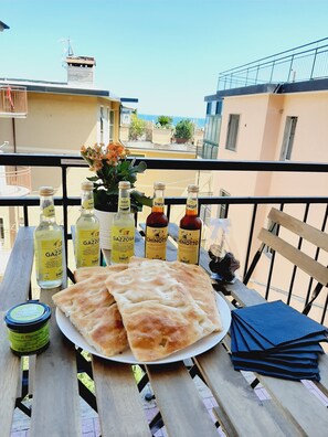 Enjoy a romantic dinner on the balcony with a view of the sea and surrounding buildings.