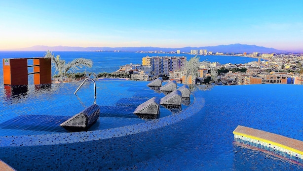An infinity pool with a view of the city and mountains in the background. - Sweeping Banderas Bay Views, Rooftop Pool & Bar - Residences by Pinnacle Unit 20 (Puerto Vallarta)