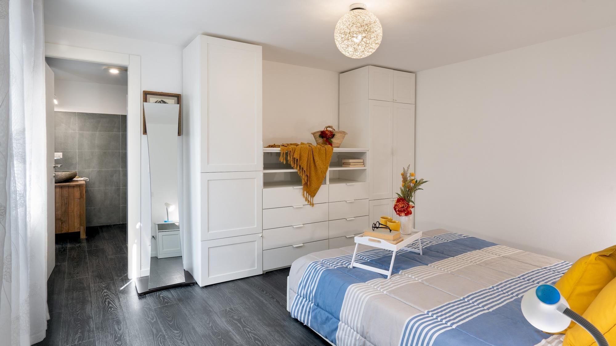 Une chambre à coucher avec un lit, une table de chevet et une armoire.
