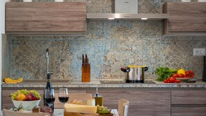 Una cocina moderna con armarios de madera, un salpicadero estampado y una olla de acero inoxidable sobre la encimera.