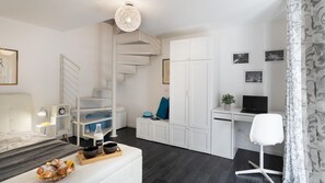 Cozy retreat with a neatly organized bed, wardrobe, and desk area.