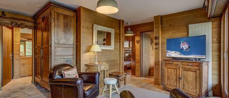 Relax in this inviting living room with a comfortable sofa, small table, and mounted TV.